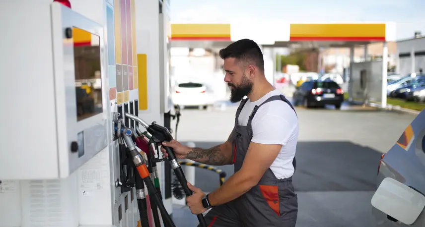 Person refilling a vehicle at a gas station