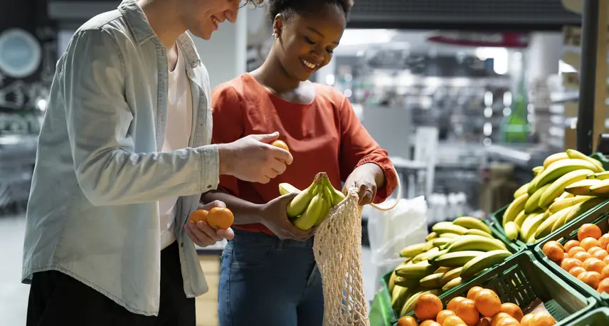 Two people choosing fruits at a grocery store