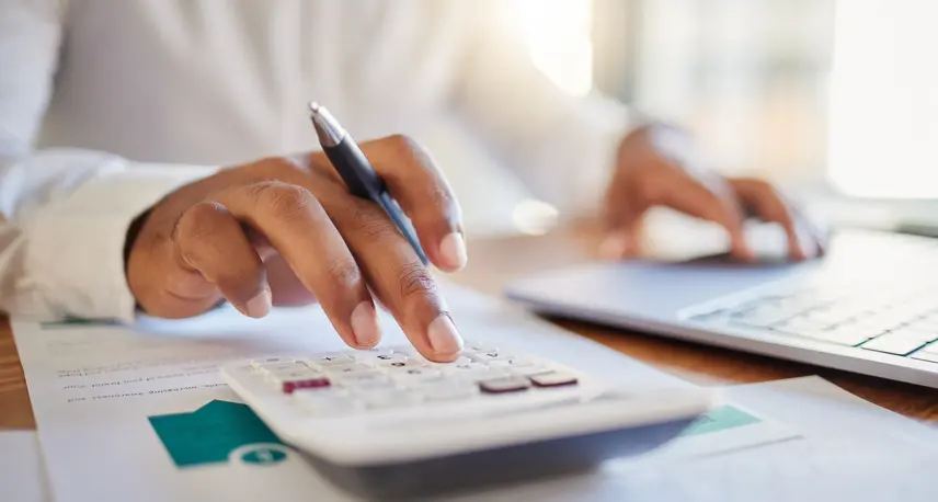 Person using a calculator and a computer